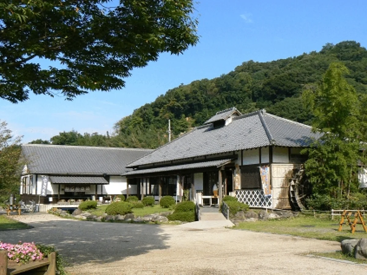 木々と山を背景に建つ道の駅花の三聖苑伊豆松崎の施設外観